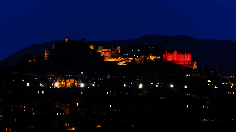 Edinburgh castle lit up with the colours of the Belgium flag
