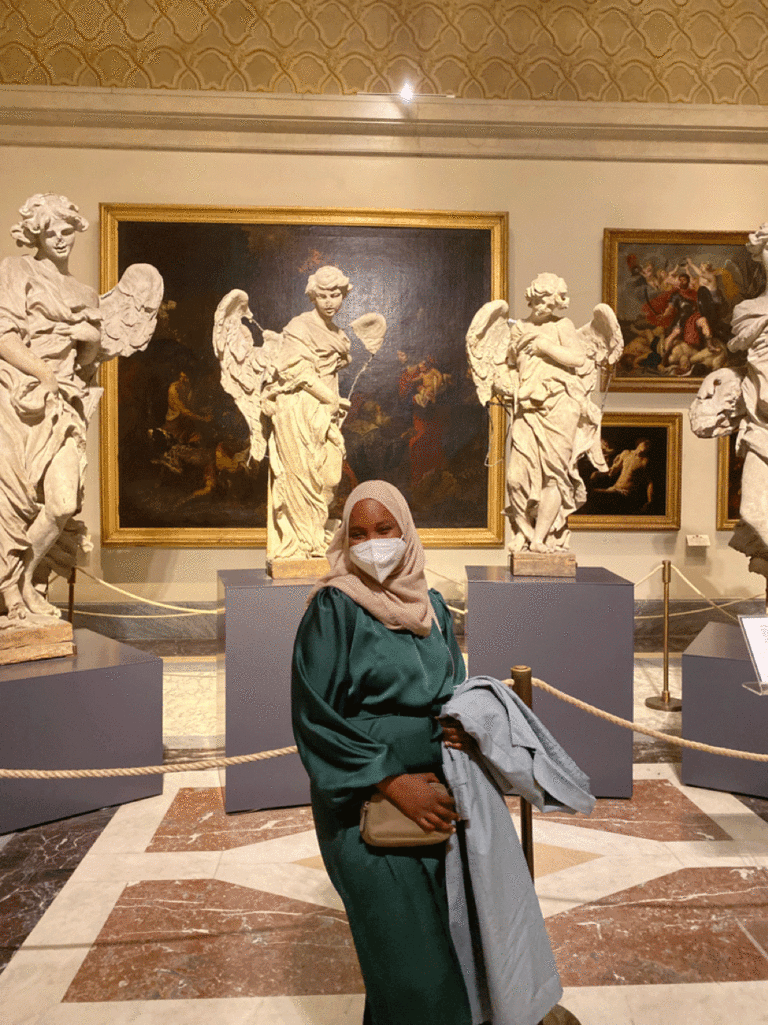 Sauda Abdullahi at the Vatican with statues in rear