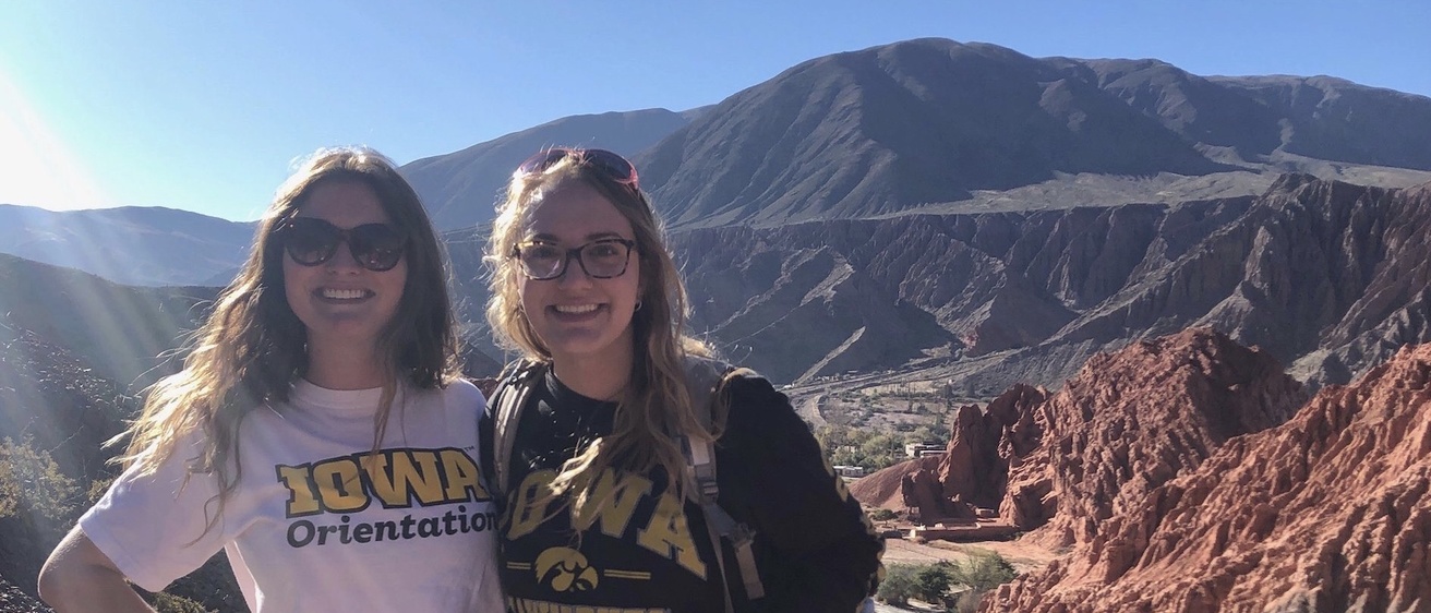 Two University of Iowa students standing in front of a mountain range in Peru.