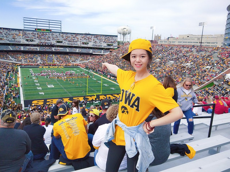student pointing at Kinnick stadium field from stands