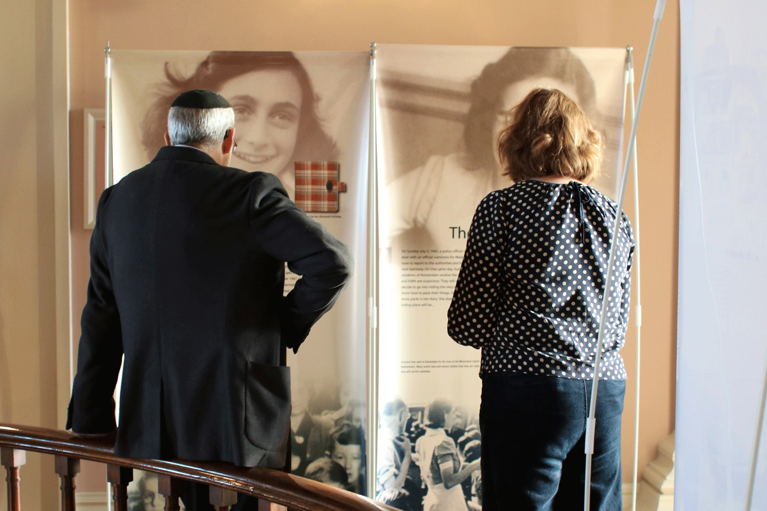 Two people looking at Anne Frank exhibit in Old Capitol