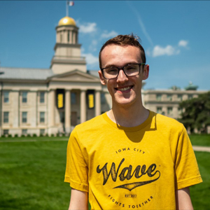 student smiling in front of old capitol building 