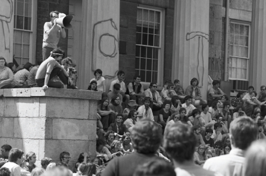 Protests during the Vietnam War with “ROTC” written on the pillars