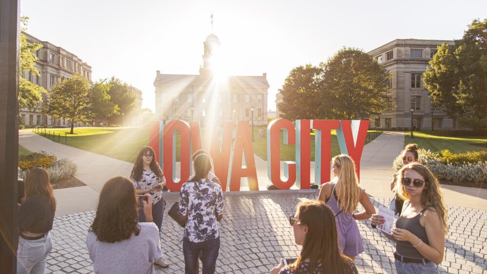 A group of students in front of Iowa City sign