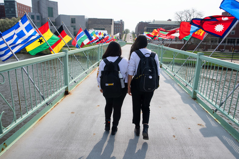 international students walking on IMU footbridge with world flags