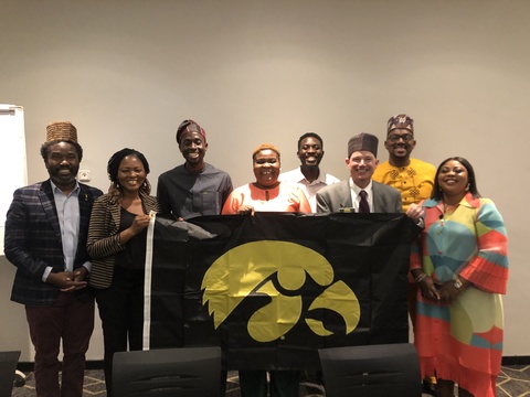 Mandela Fellows alumni with Dimy and Russ in Lagos holding Hawkeye flag