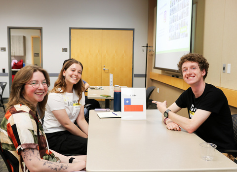 students at Slice of Advice event sitting at table with sign that has the Chilean flag