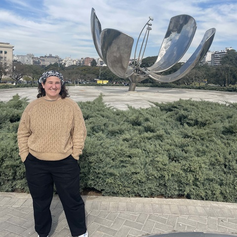 Ellie Crock standing in front of a silver flower statue in Buenos Aires
