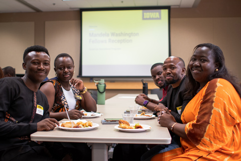 Group of Mandela Washington Fellows sitting at table smiling at camera