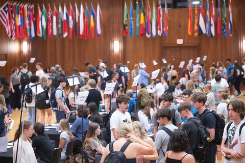 students talking at tables at the Study Abroad Fair