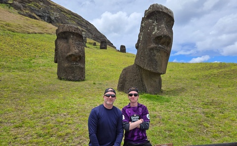 Sean Keene and his father outside by statues on Easter Island
