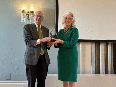 Russ Ganim presenting the International Impact Award to Karri Goeldner Byrne