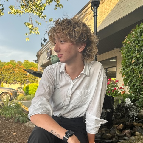 Nic Cazin sitting on a rock looking left, headshot