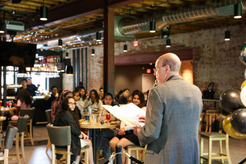 Russ Ganim speaking in front of group of seated international students at restaurant