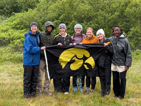 students holding Hawkeye flag in Iceland