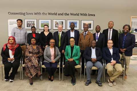 Group of visitors seated and standing in International Programs office
