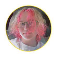 student with pink hair and blue glasses