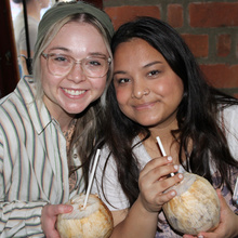 two students pose with coconut drinks