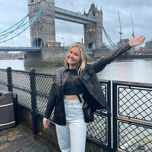 student poses with outstretched arm in London
