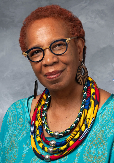 person wearing glasses and colorful beaded necklaces