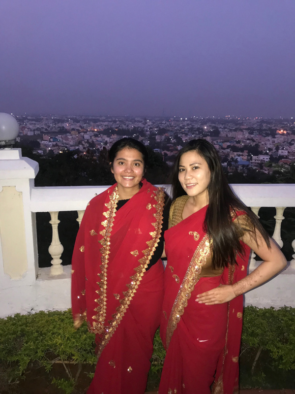 Carolyn Lo and friend in saris on balcony