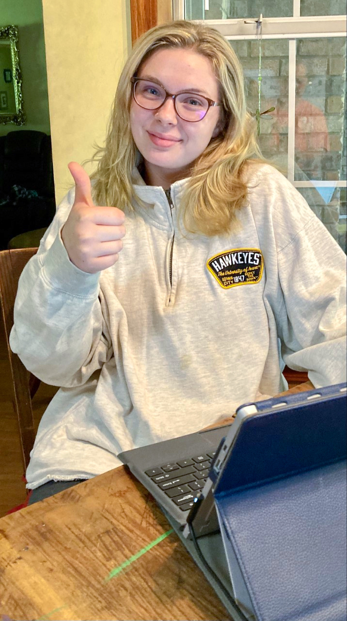 student at computer giving thumbs up