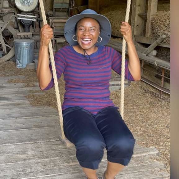 Onyeche Oche on a swing at a local Iowa farm