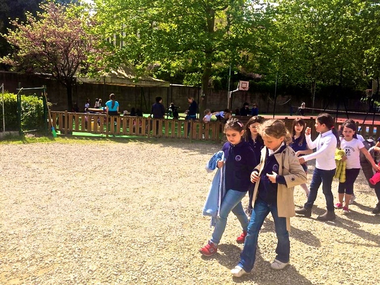 A group of children playing in a schoolyard in Italy.