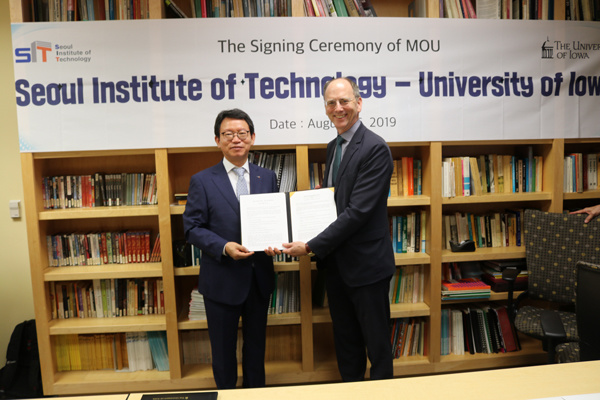 Downing Thomas and the president of Seoul Institute of Technology holding agreement