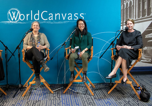 Sabine Golz, Adrienne Rose and Laura McClure, seated in front of WorldCanvass sign