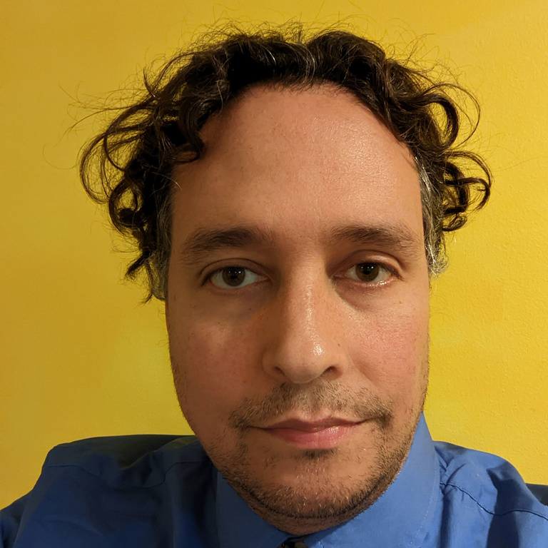 profile image wearing blue shirt in front of yellow background