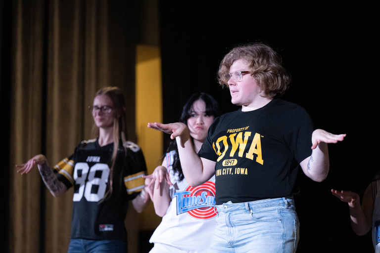 students dancing, one wearing Iowa shirt
