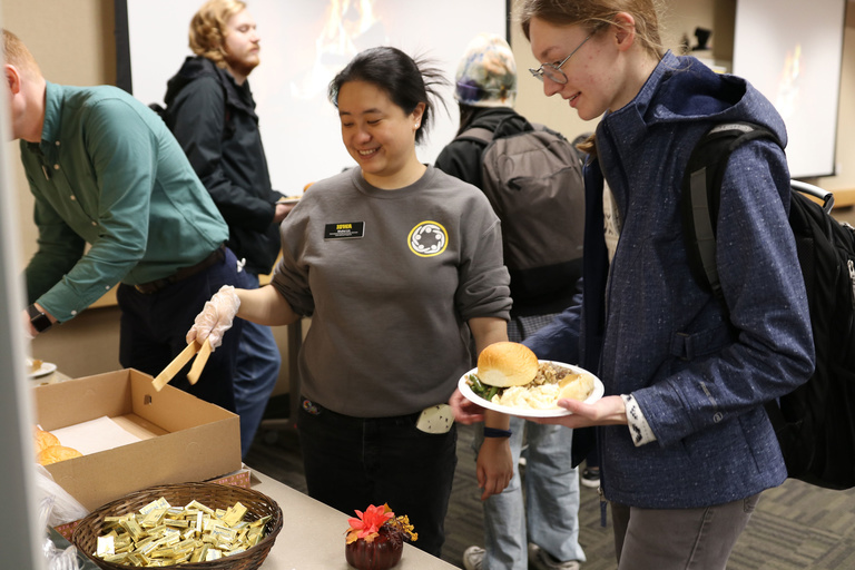 Shuhui Lin serving food to student