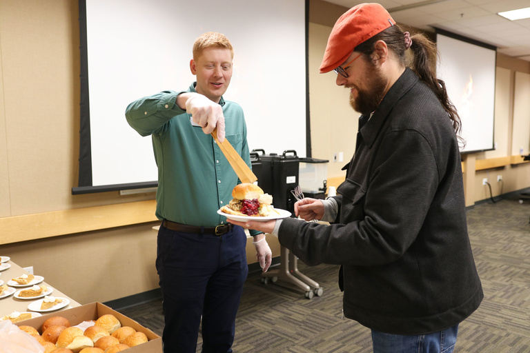 Brandon Paulson serving food to student