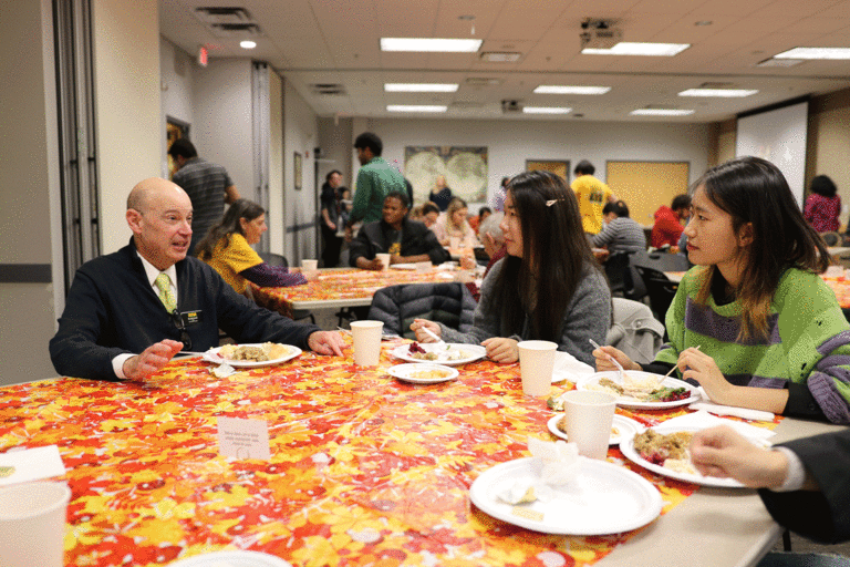 two students speaking with Russ Ganim