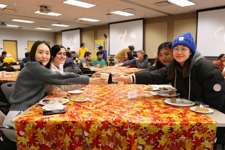 students clinking glasses at table