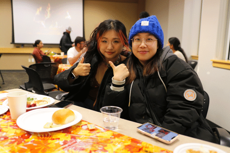 two students at table smiling