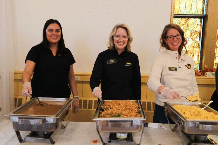 three staff members serving food