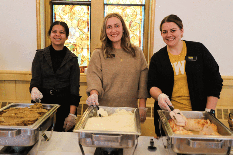 three staff members serving food
