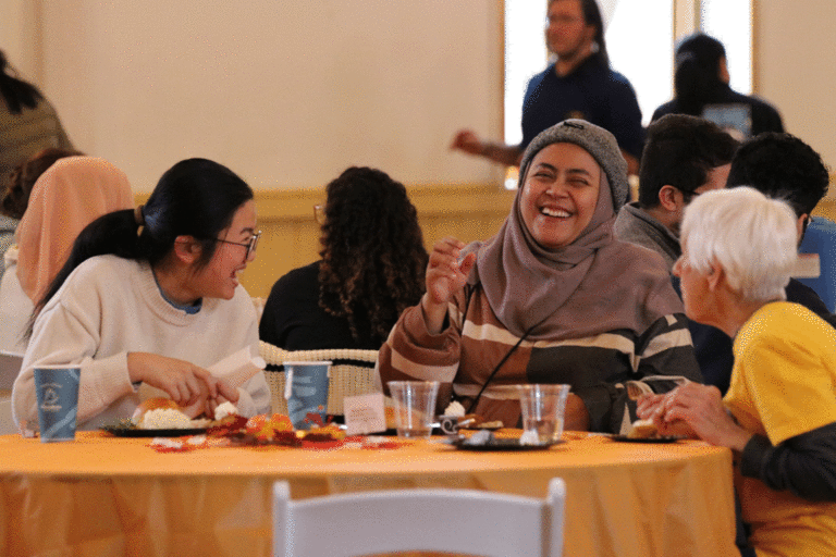 two students and a community member laughing