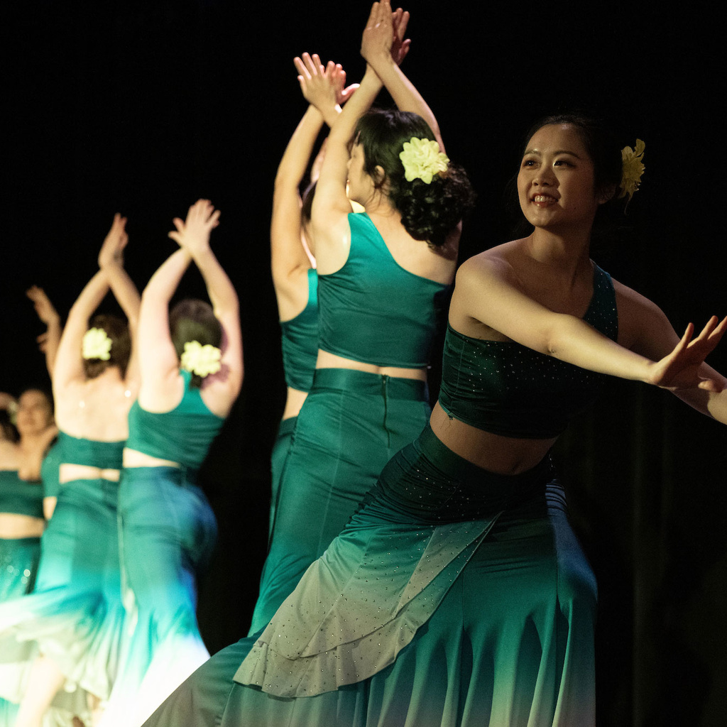dancers in green dresses with yellow flowers in their hair