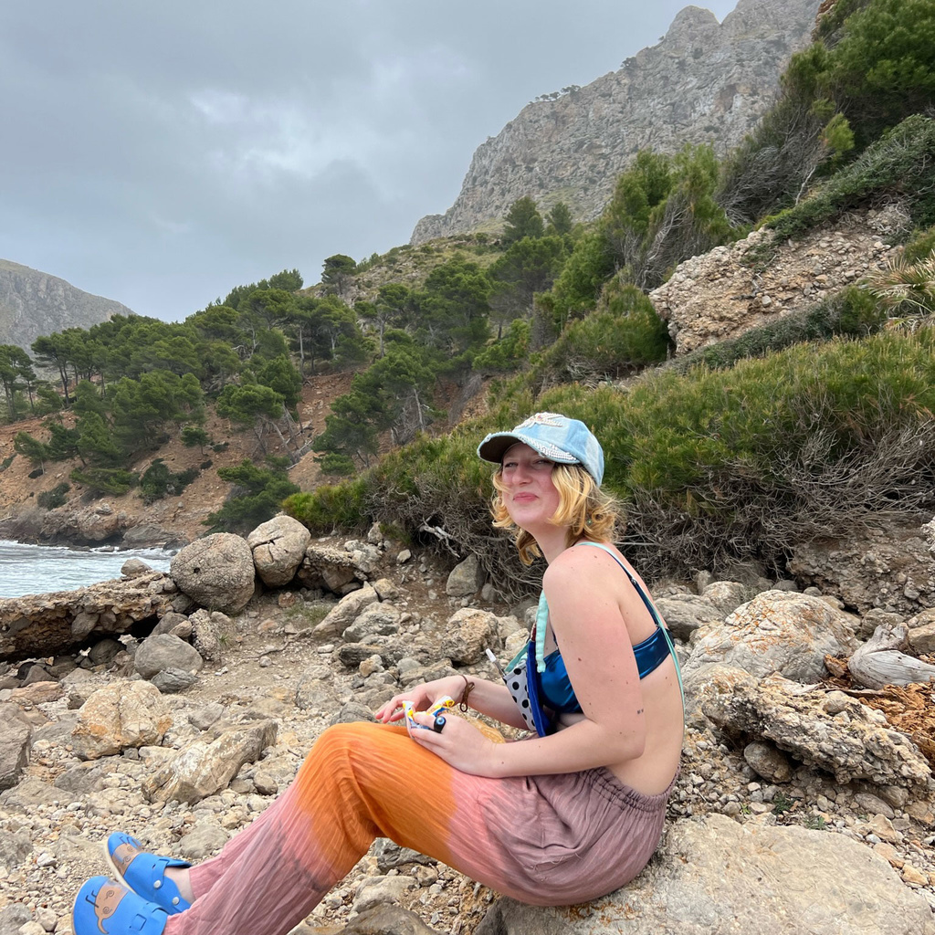 Eva Packer sitting on rocks near water