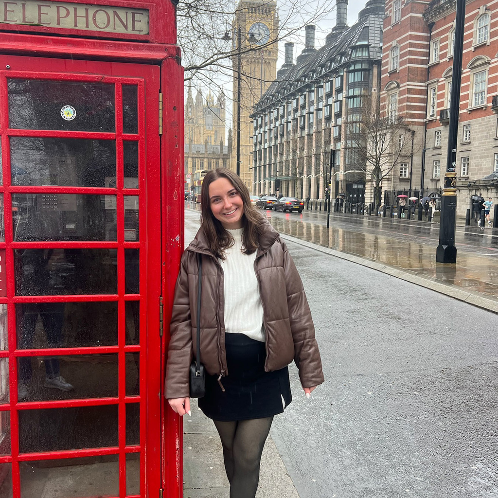 Kate Burns standing next to red phone box on London street