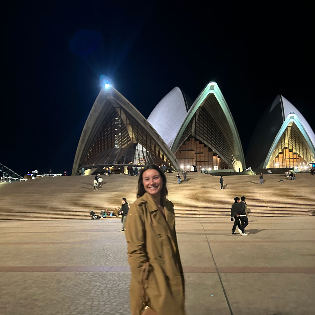 Paige Pearson standing in front of Sydney Opera House at night