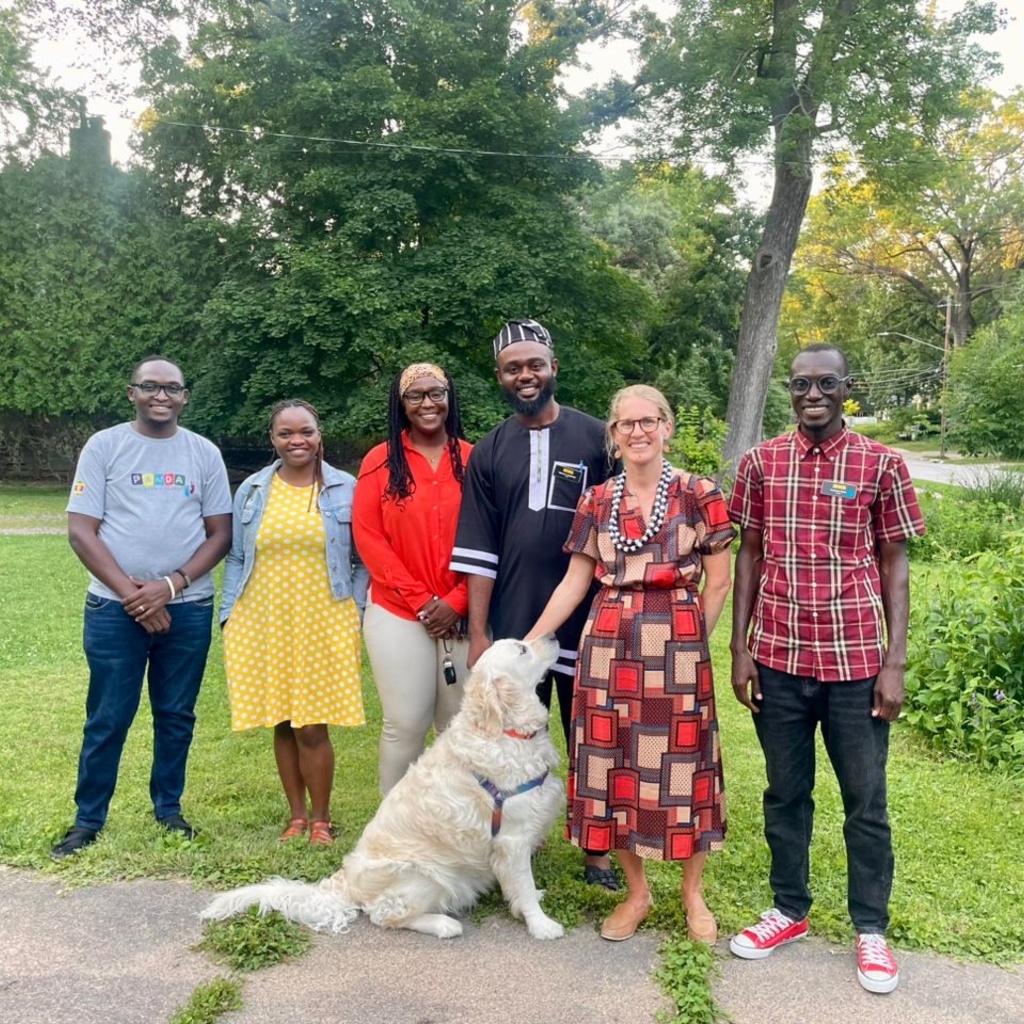 group of people smiling with dog sitting in front of them