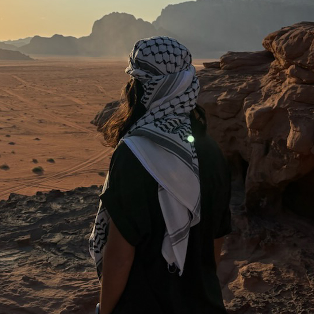 Student wearing head scarf overlooking desert