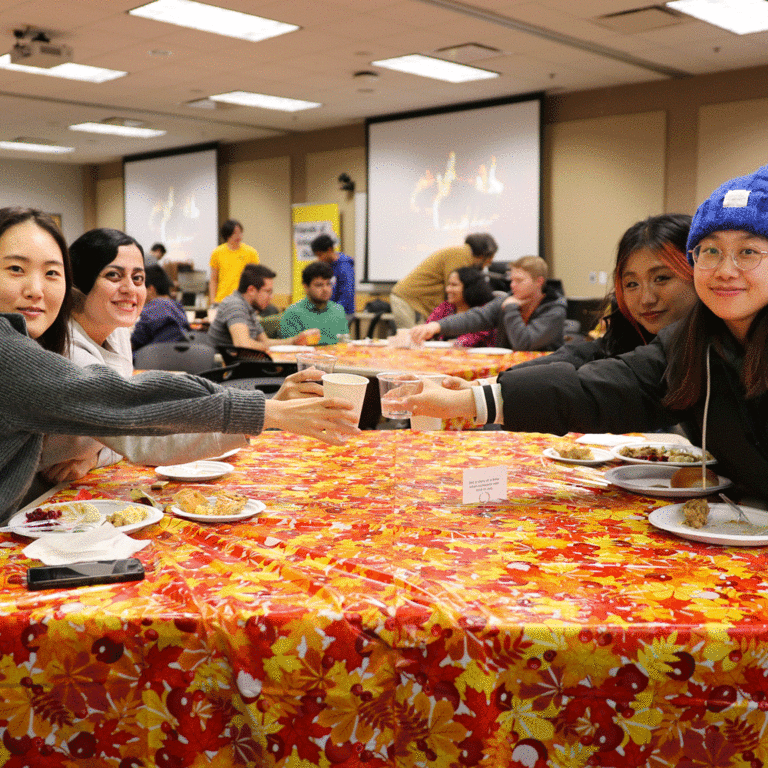 students clinking glasses at table