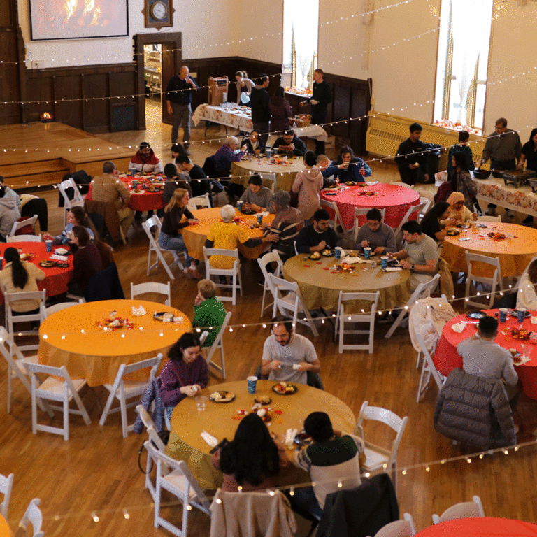 bird's eye view of round tables with colorful tablecloths and people eating and talking
