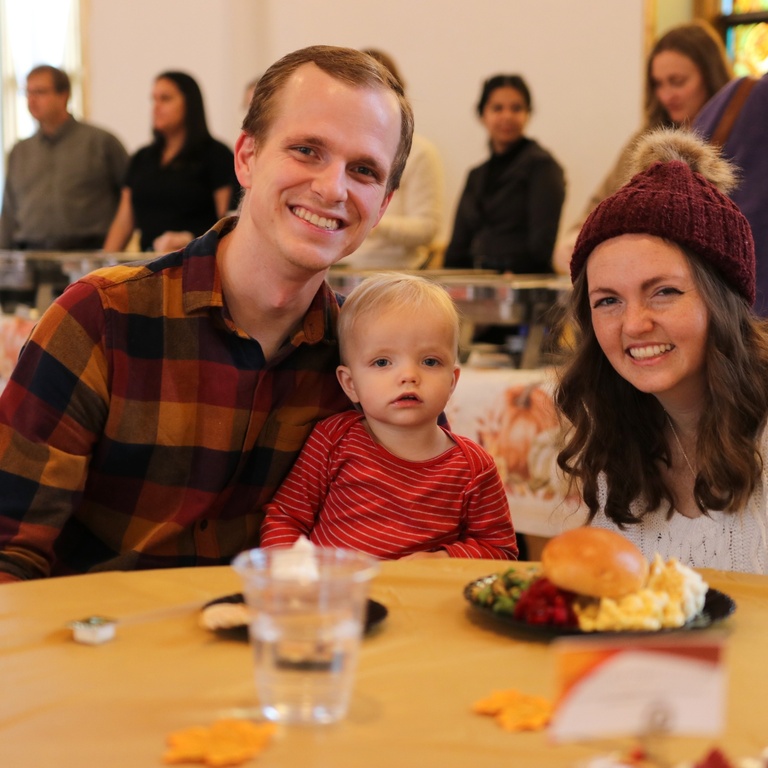 A young family enjoying fall break meal food with their child