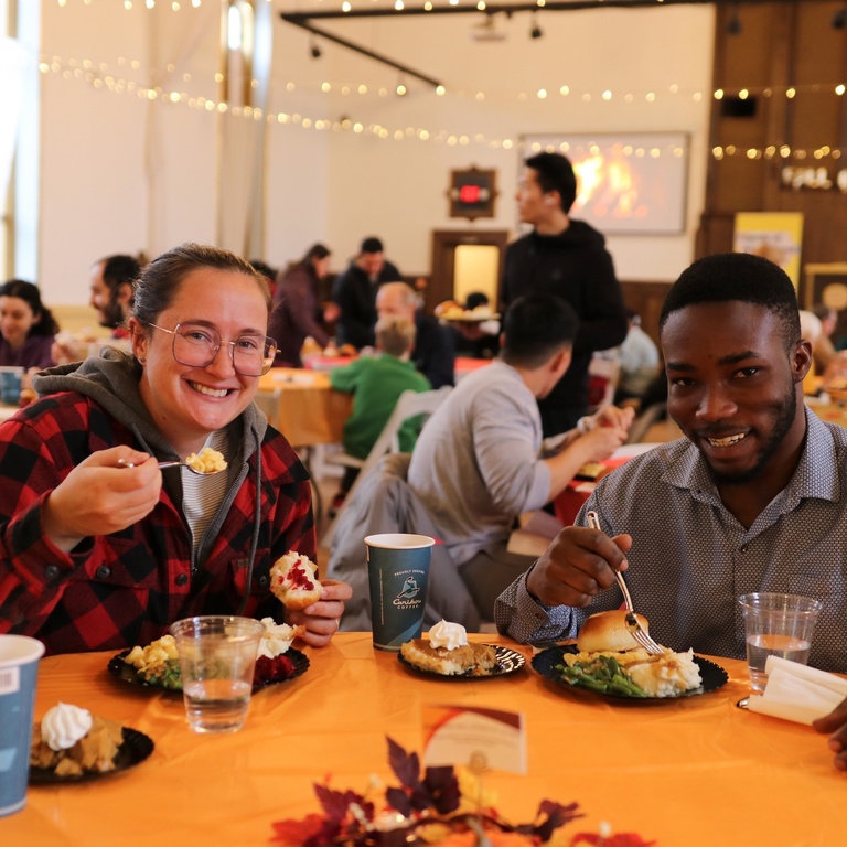 two people enjoying the fall break meal with tables in the background